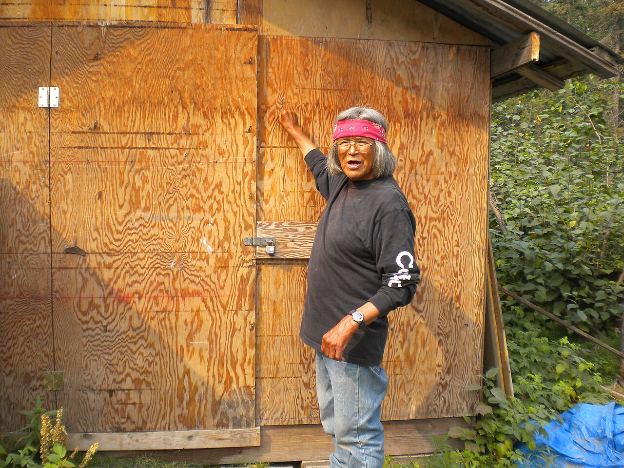 A resident points to the high-water line left on an interior wall after floodwater has receded.